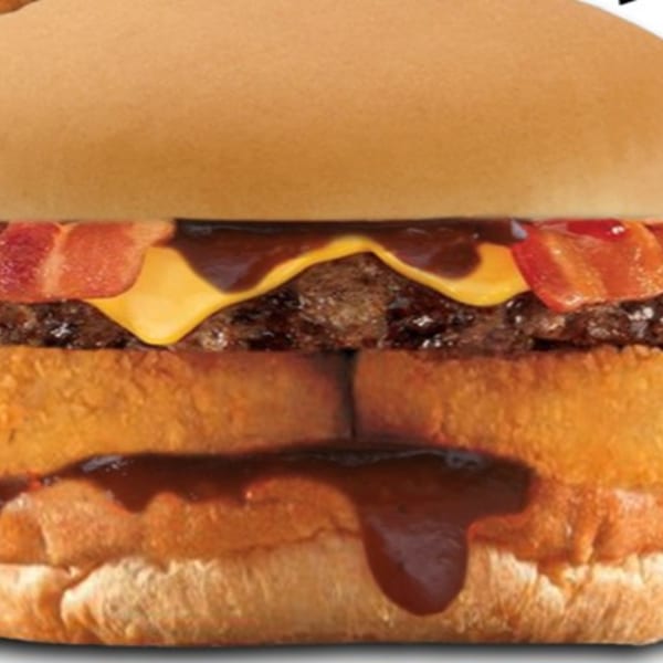 Jim's Burgers bacon cheeseburger with hash browns and barbecue sauce dripping down.