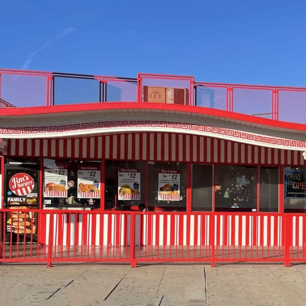 Jim's Burgers restaurant exterior with red and white striped awning and red fencing under a blue sky.